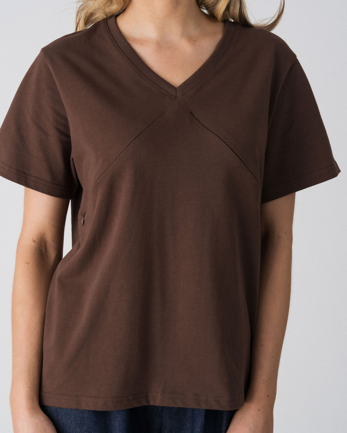 Close-up of the V-neckline and diagonal seam detail on the Lenelly Avery nursing tee in brown