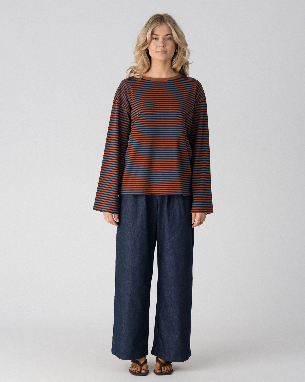 Lenelly Lena oversized long sleeve nursing tee in brown and navy stripe, a breastfeeding-friendly top styled with wide leg indigo jeans, front view