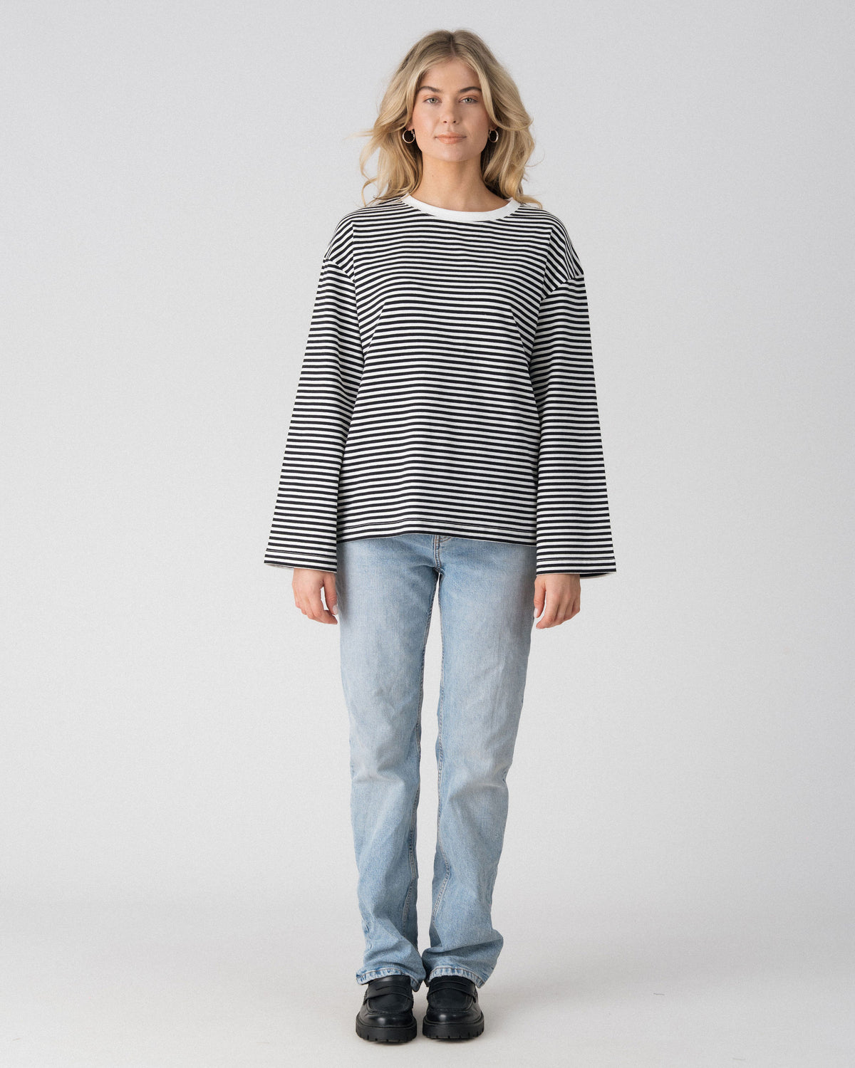 Lenelly Lena oversized long sleeve nursing tee in black and white stripe, a breastfeeding-friendly top styled with light wash jeans, front view