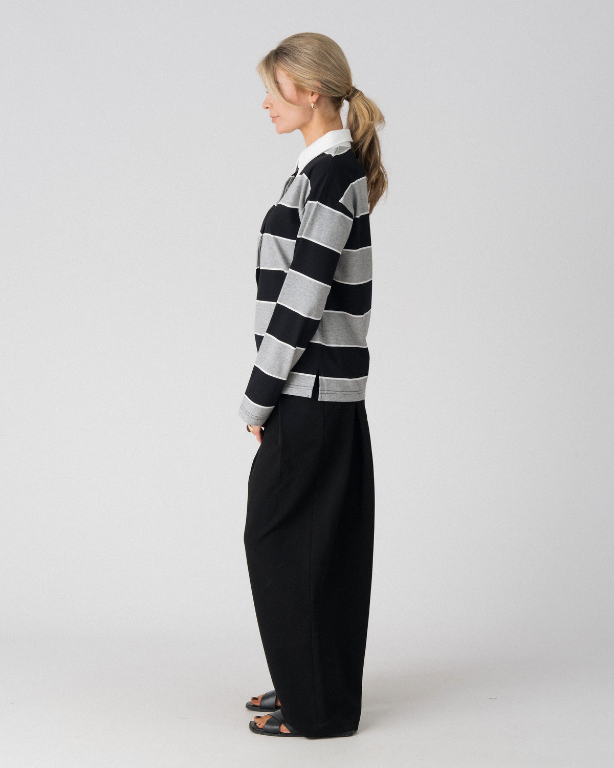 Lenelly Erika rugby polo in black and grey stripe, side view showing the relaxed fit