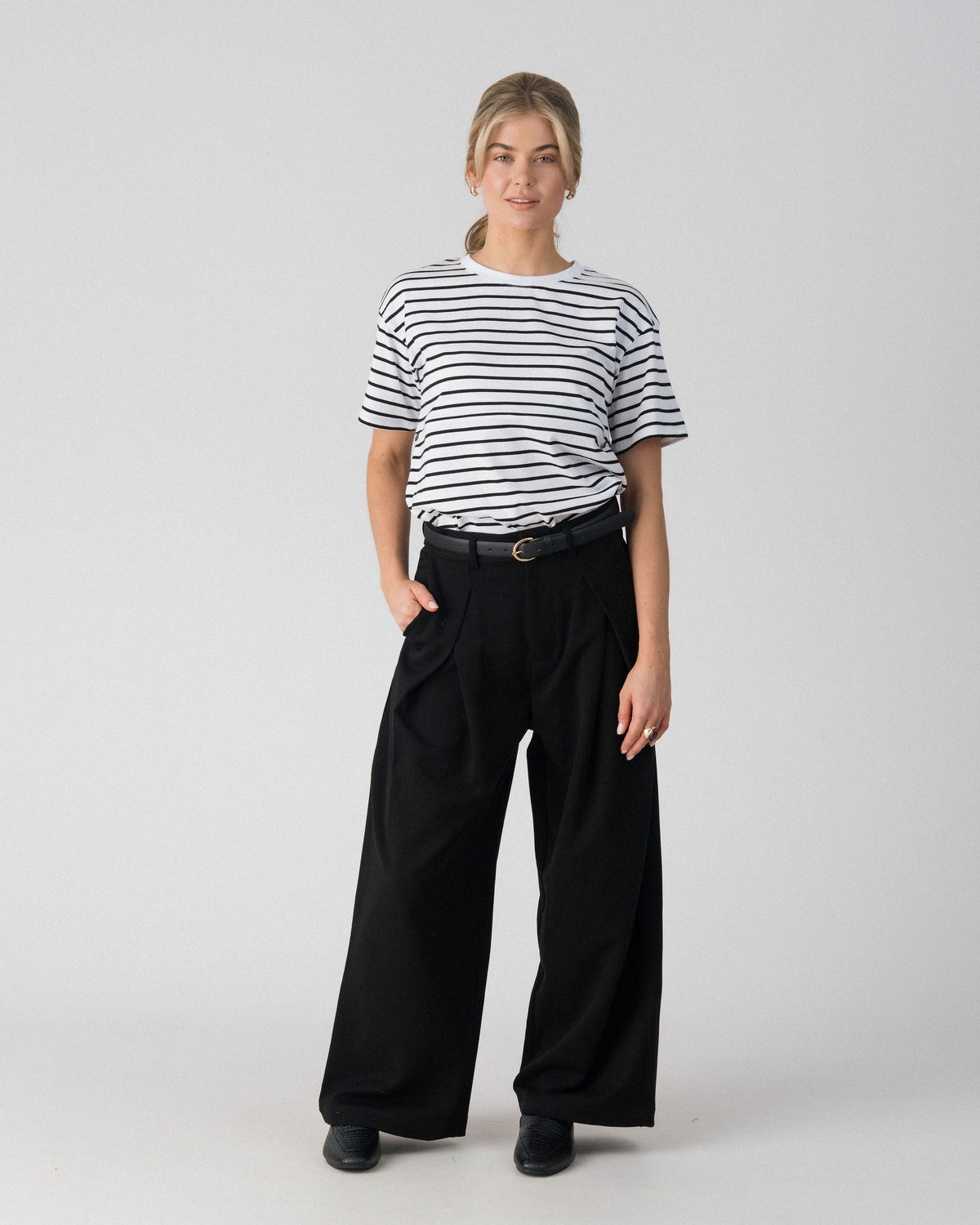 Lenelly Issa striped nursing tee in white and black styled with black wide leg trousers and a belt, front view
