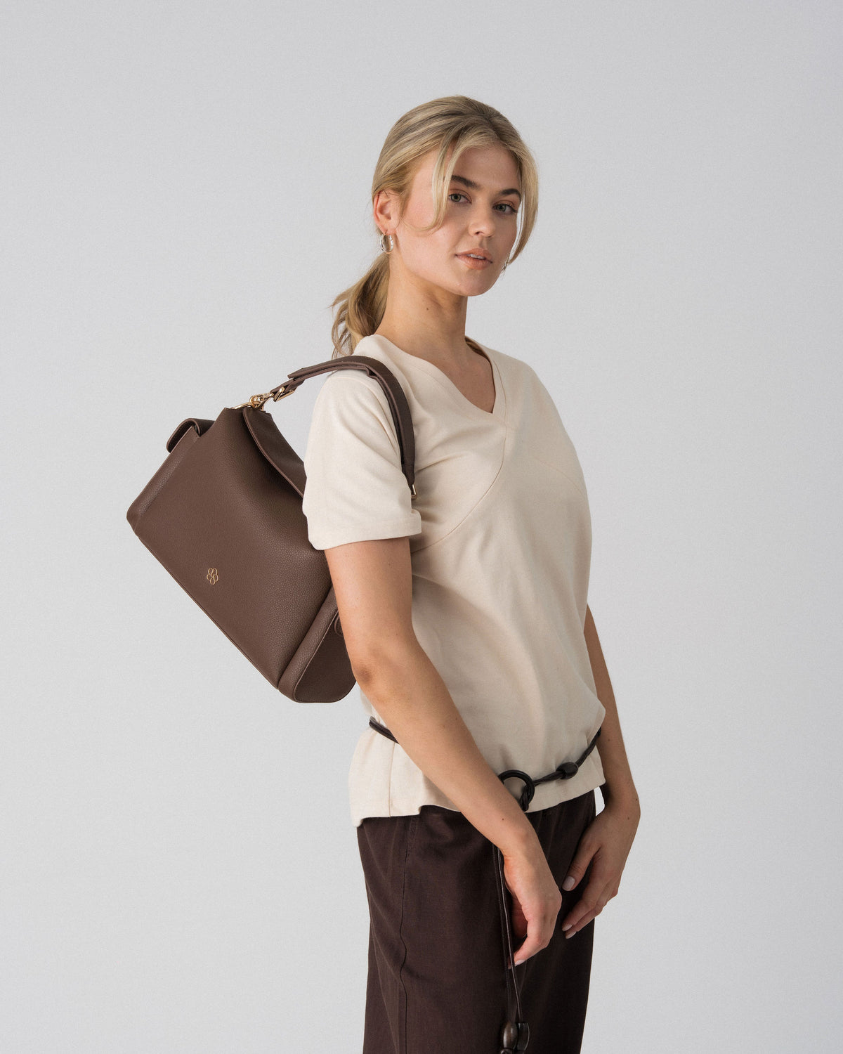 Lenelly Avery V-neck tee in sand worn with the Lenelly Hera pram caddy bag in chocolate carried over the shoulder
