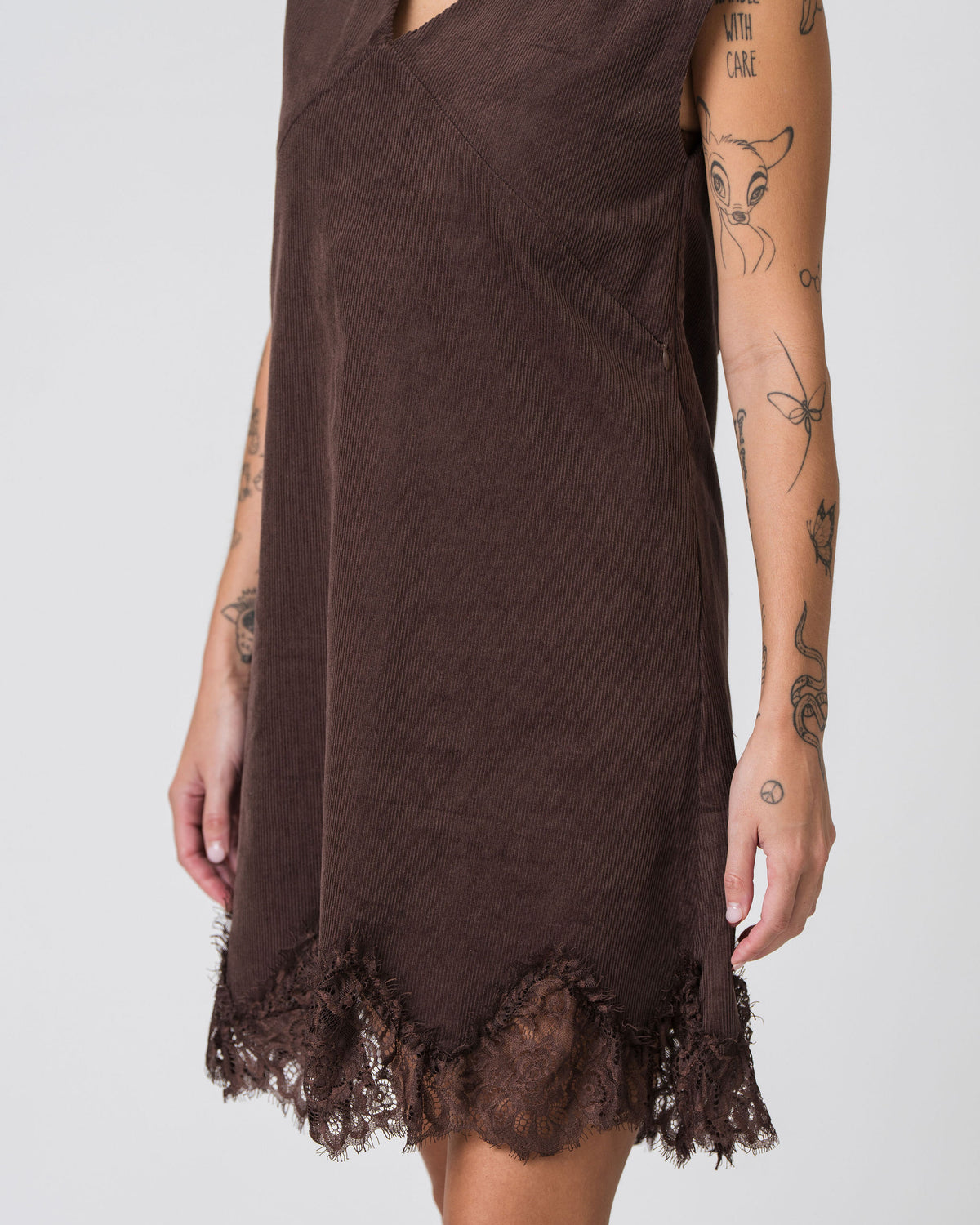 Close-up of the lace trim hem and corduroy texture on the Lenelly Audrey nursing dress in chocolate brown