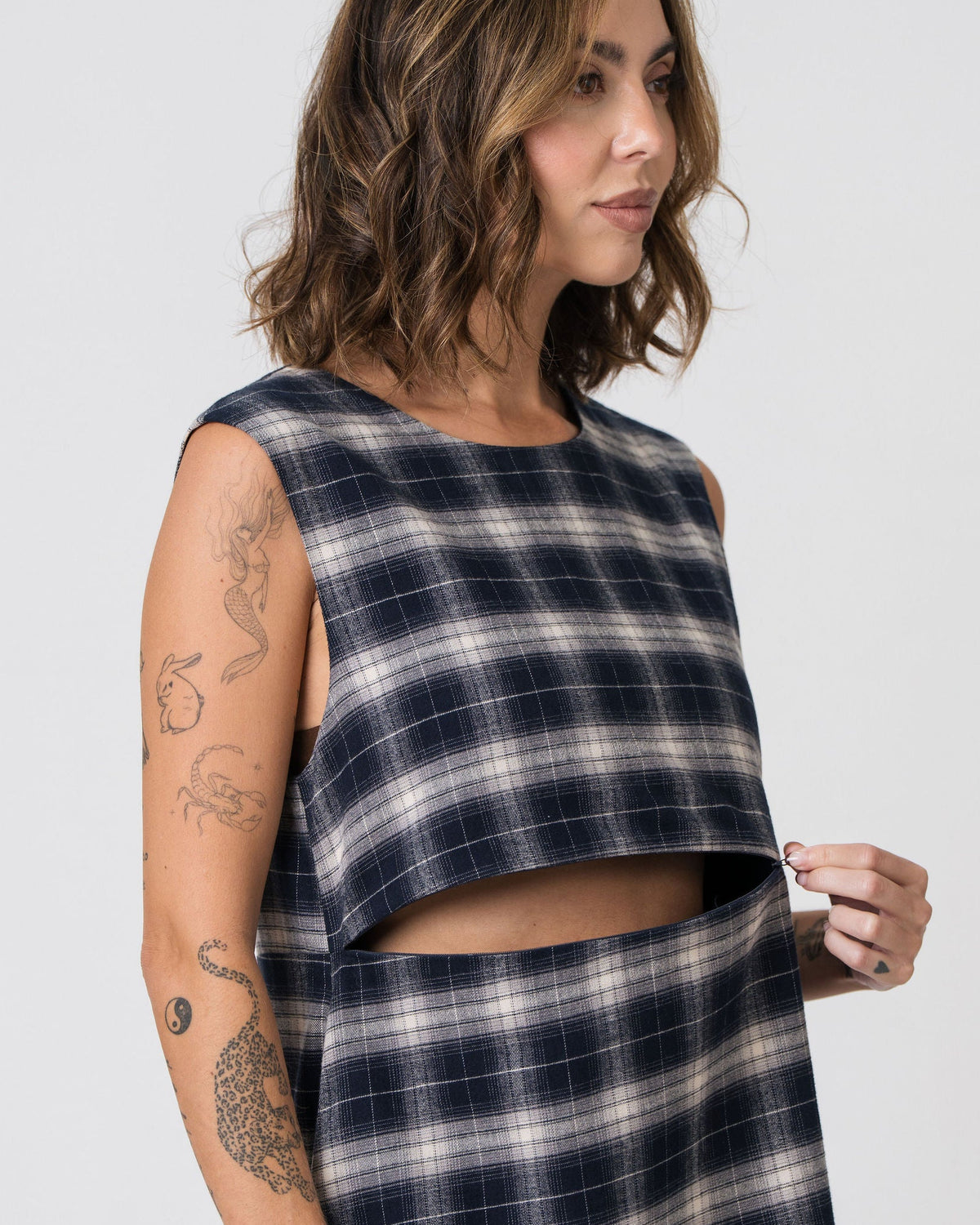 Model lifting the underbust panel of the Lenelly Bridget flannel dress to show the hidden horizontal zip for discreet breastfeeding access