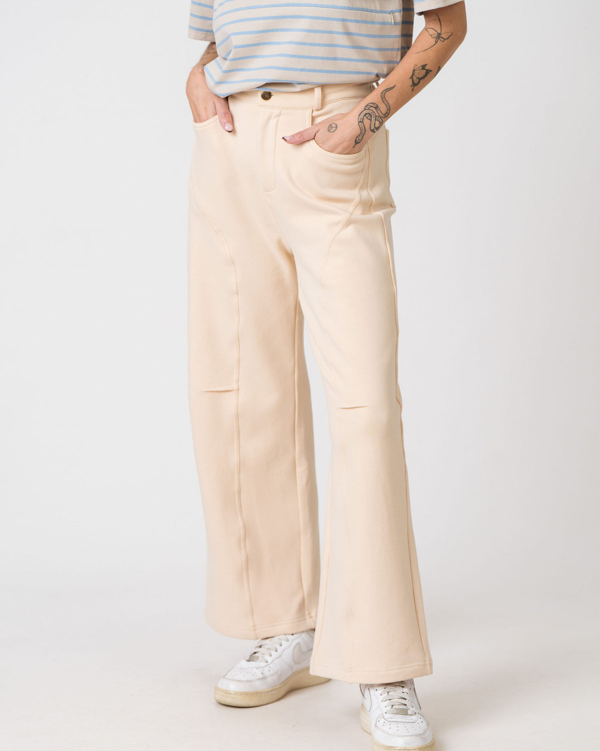 Lenelly Mish sweatpants in apricot showing the button and zip front and side pockets, cropped front view