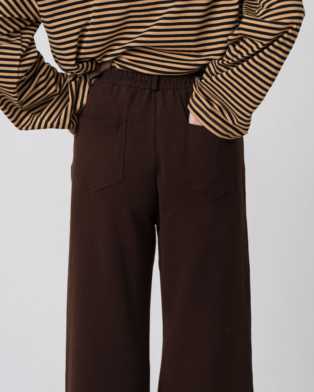 Close-up of the elasticated waistband and back patch pockets on the Lenelly Mish sweatpants in chocolate