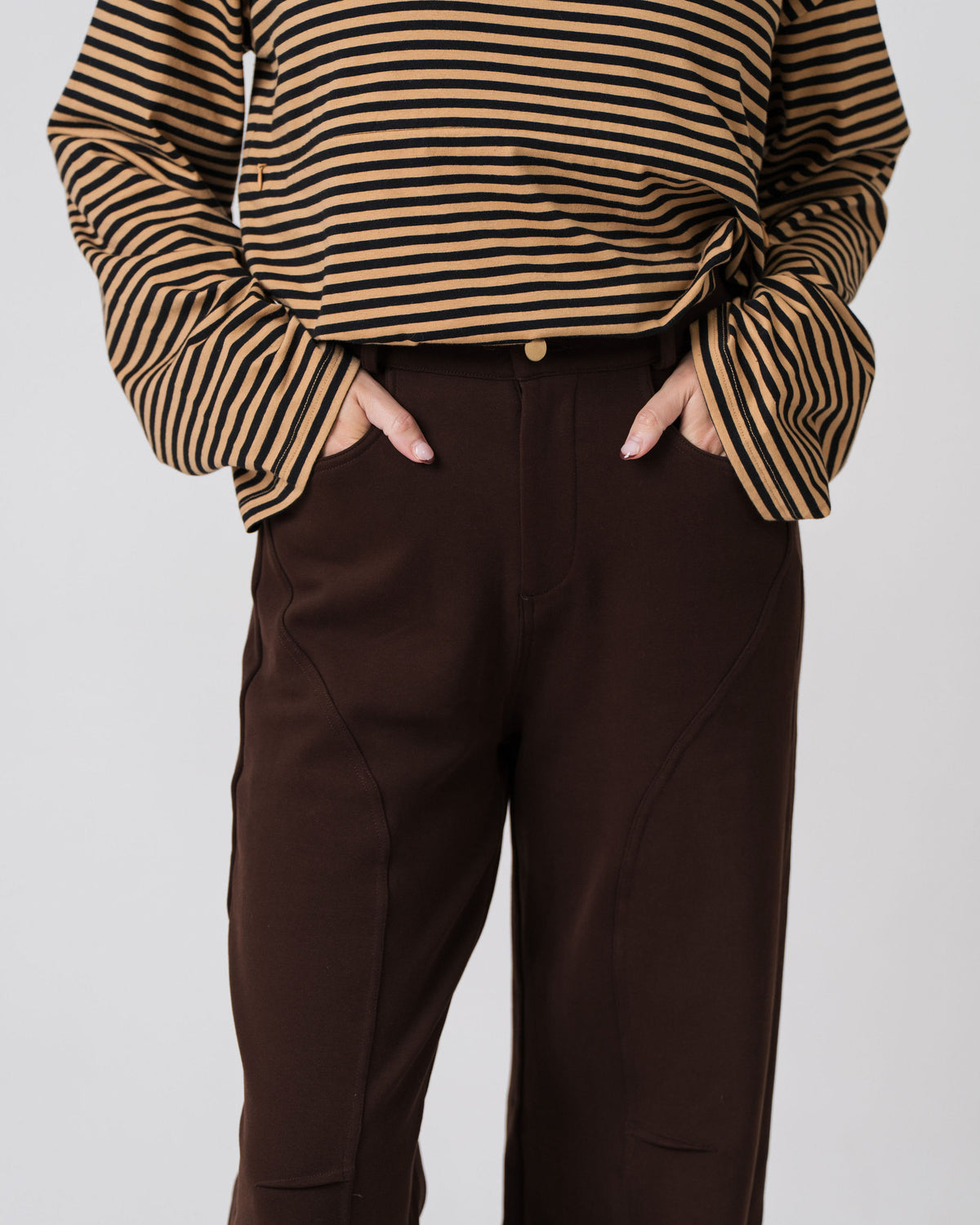 Close-up of the button and zip front and curved seam detailing on the Lenelly Mish sweatpants in chocolate