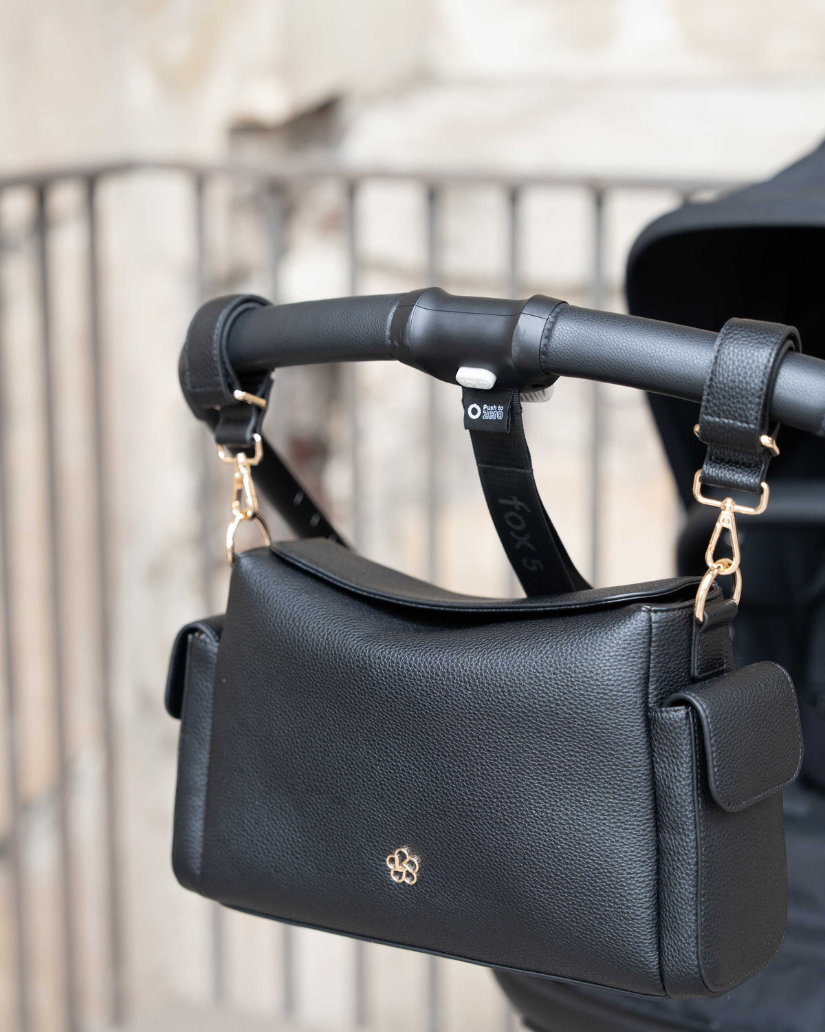 Lenelly Hera pram caddy attached to a pram handlebar, front view outdoors