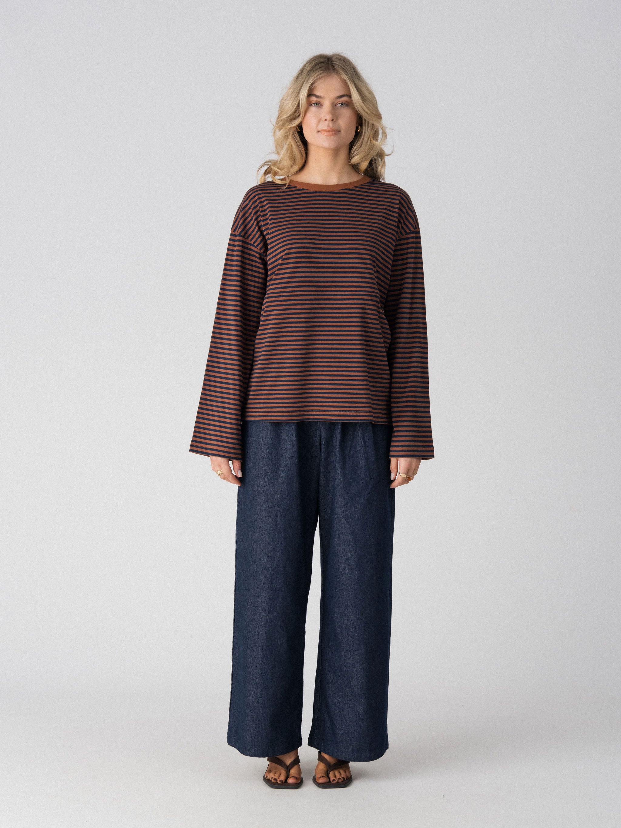 Lenelly Lena oversized long sleeve nursing tee in brown and navy stripe, a breastfeeding-friendly top styled with wide leg indigo jeans, front view