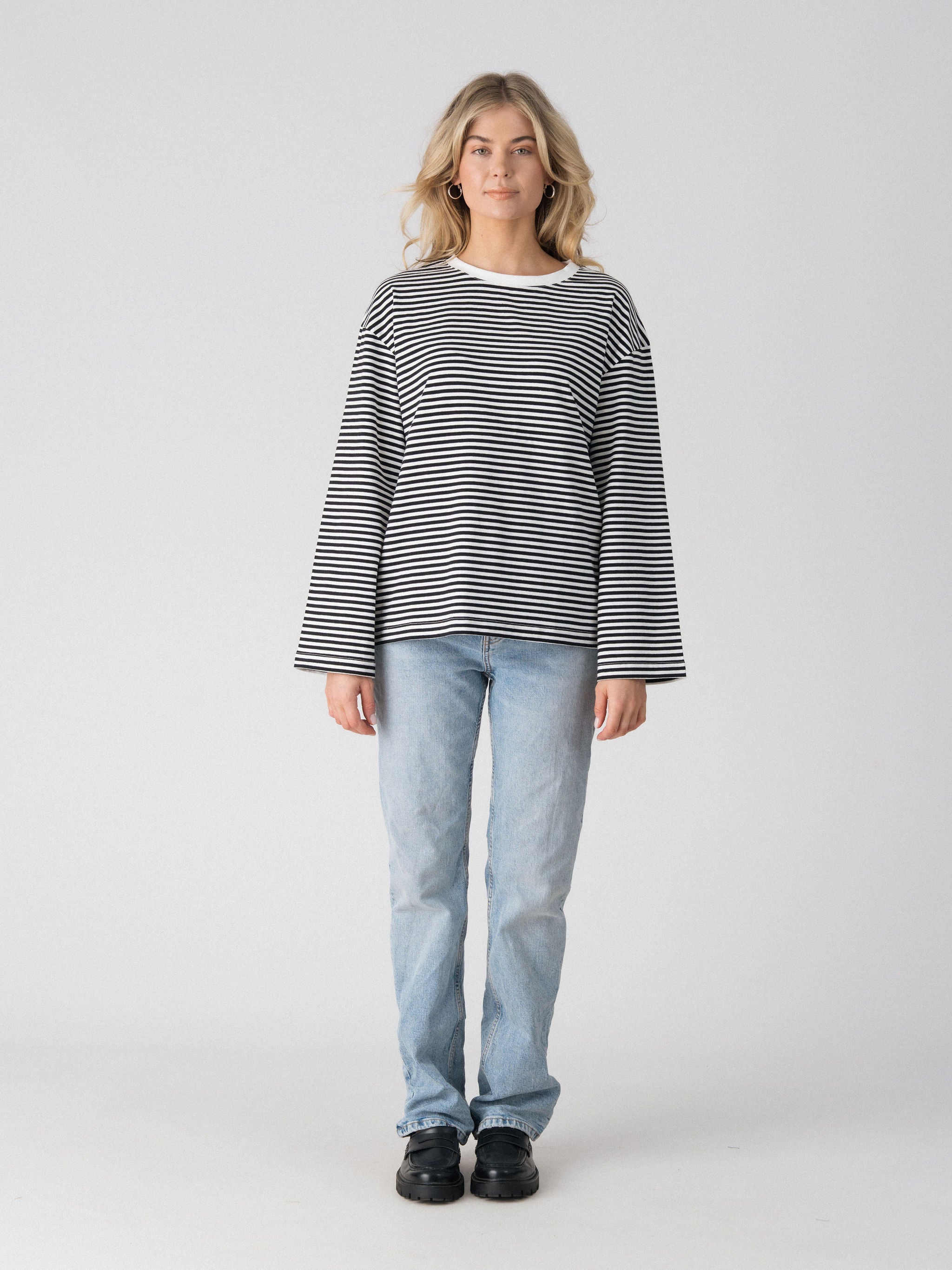 Lenelly Lena oversized long sleeve nursing tee in black and white stripe, a breastfeeding-friendly top styled with light wash jeans, front view