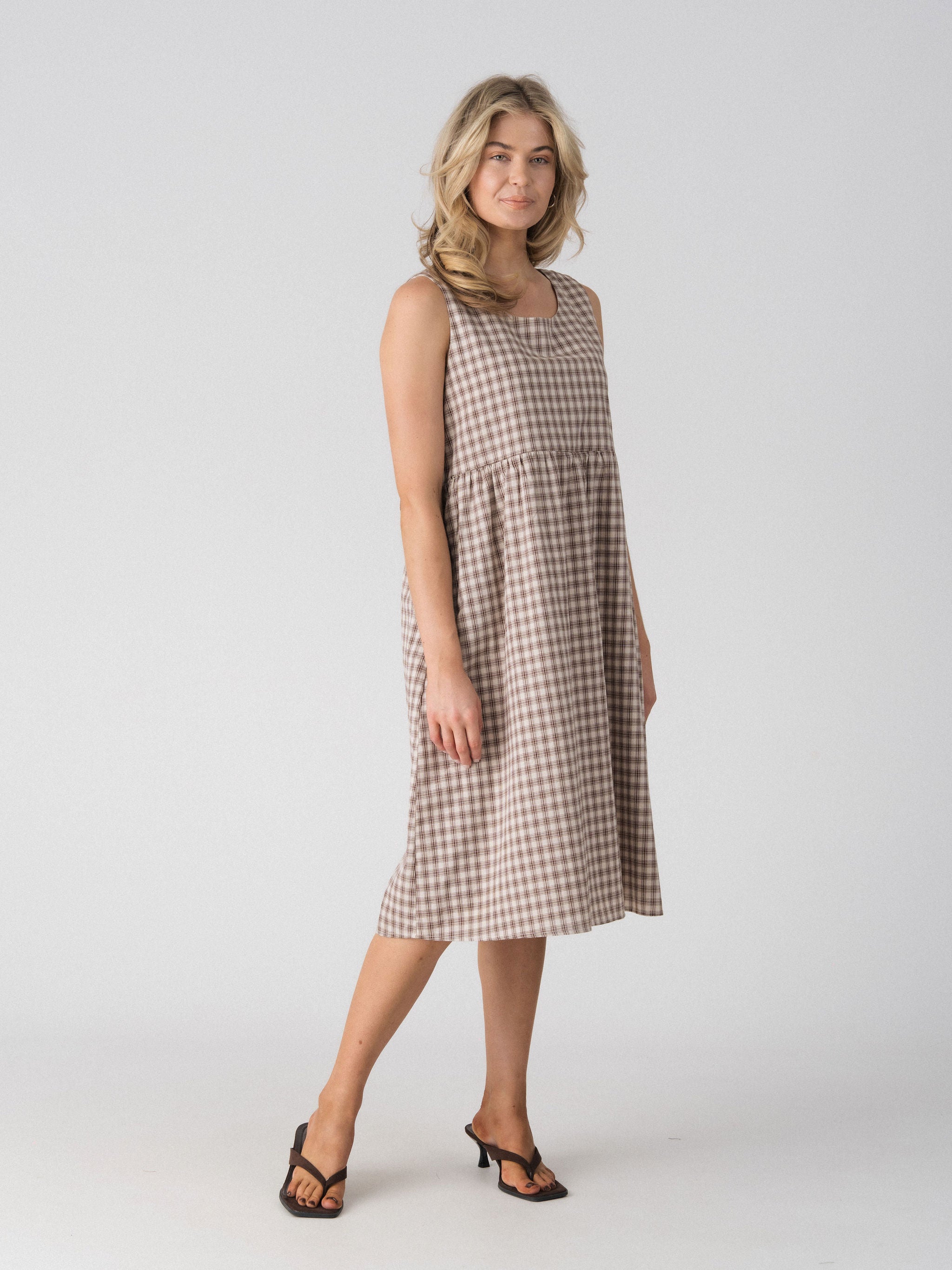 Lenelly Nila plaid midi dress in beige and brown check, angled view showing the relaxed babydoll silhouette
