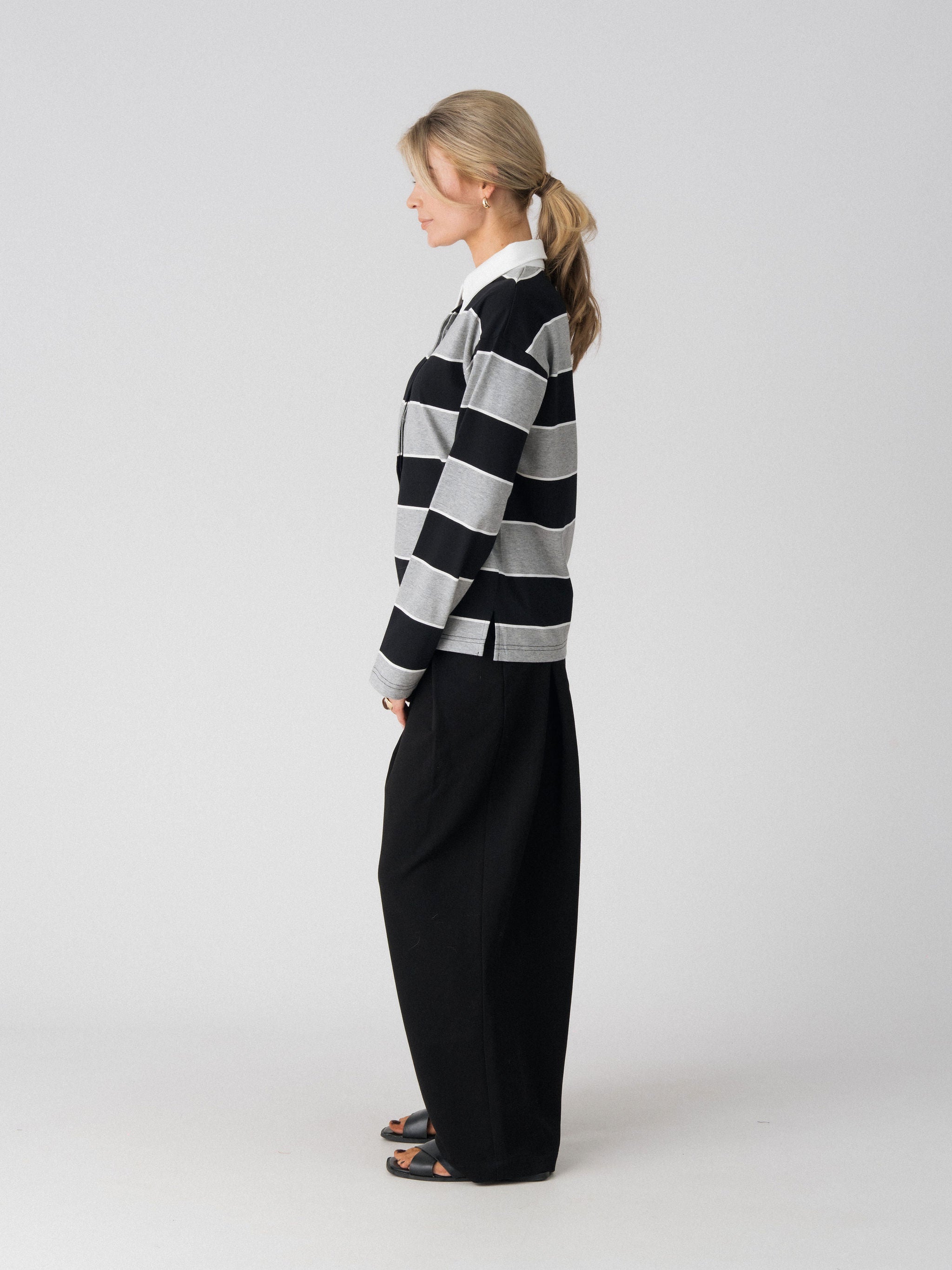 Lenelly Erika rugby polo in black and grey stripe, side view showing the relaxed fit