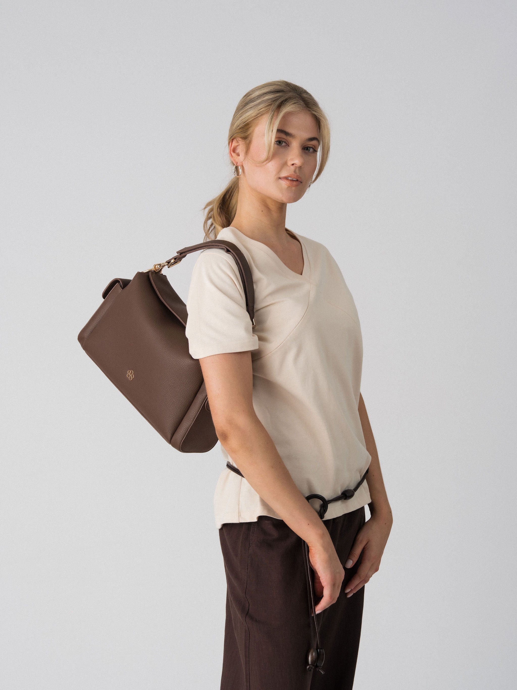 Lenelly Avery V-neck tee in sand worn with the Lenelly Hera pram caddy bag in chocolate carried over the shoulder