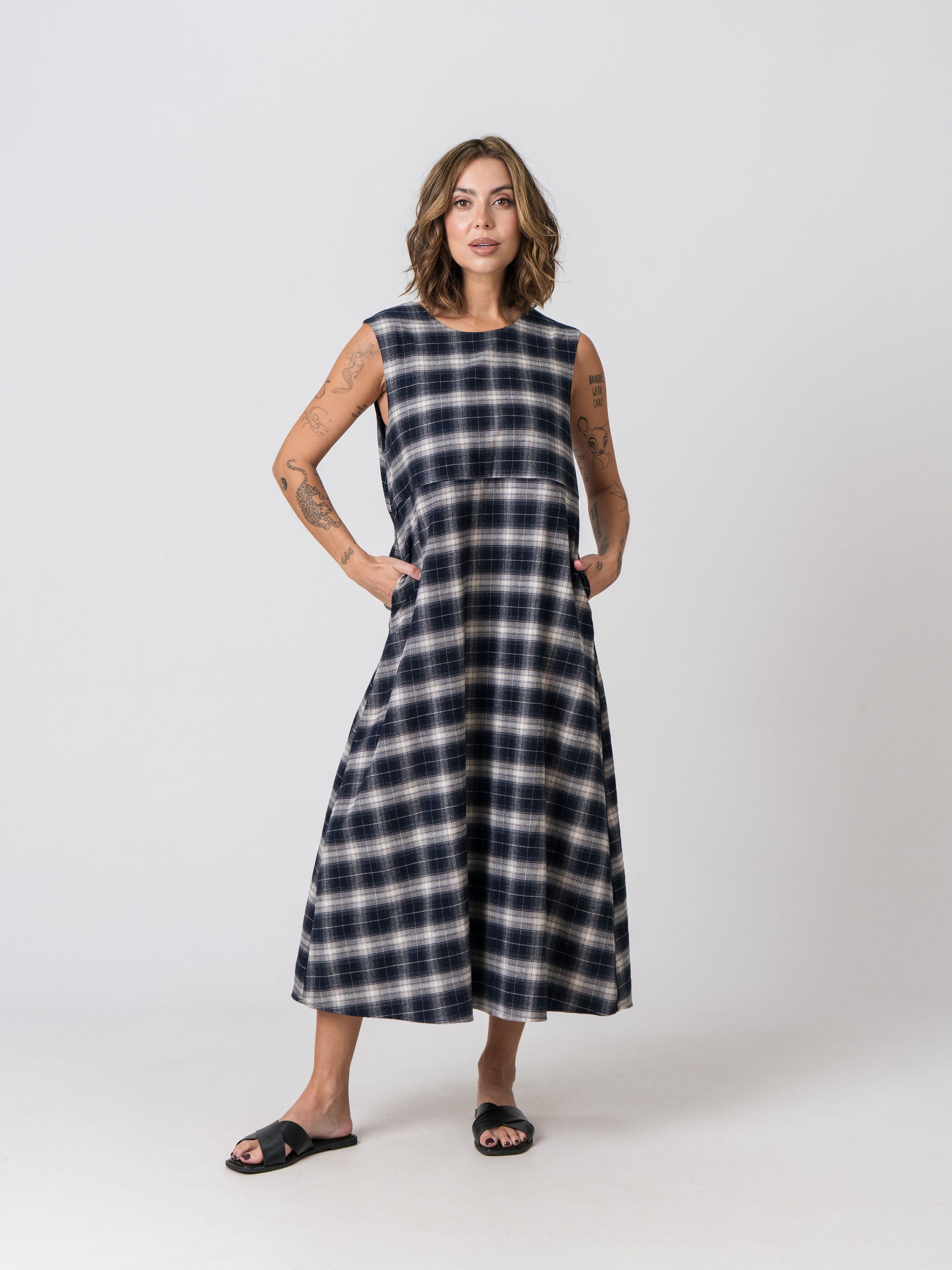 Lenelly Bridget nursing dress in navy and cream plaid with hands in the functional side pockets, front view