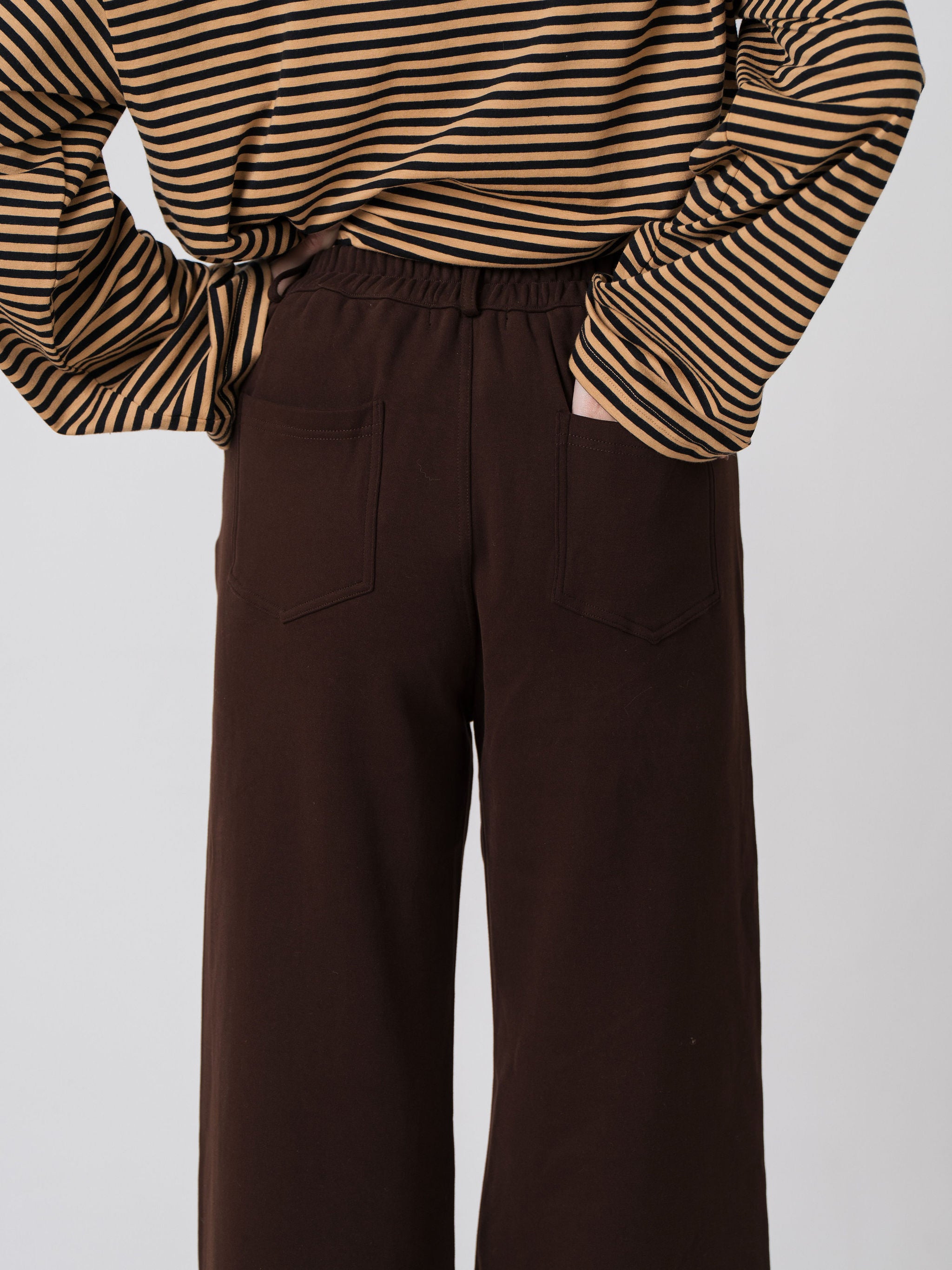 Close-up of the elasticated waistband and back patch pockets on the Lenelly Mish sweatpants in chocolate