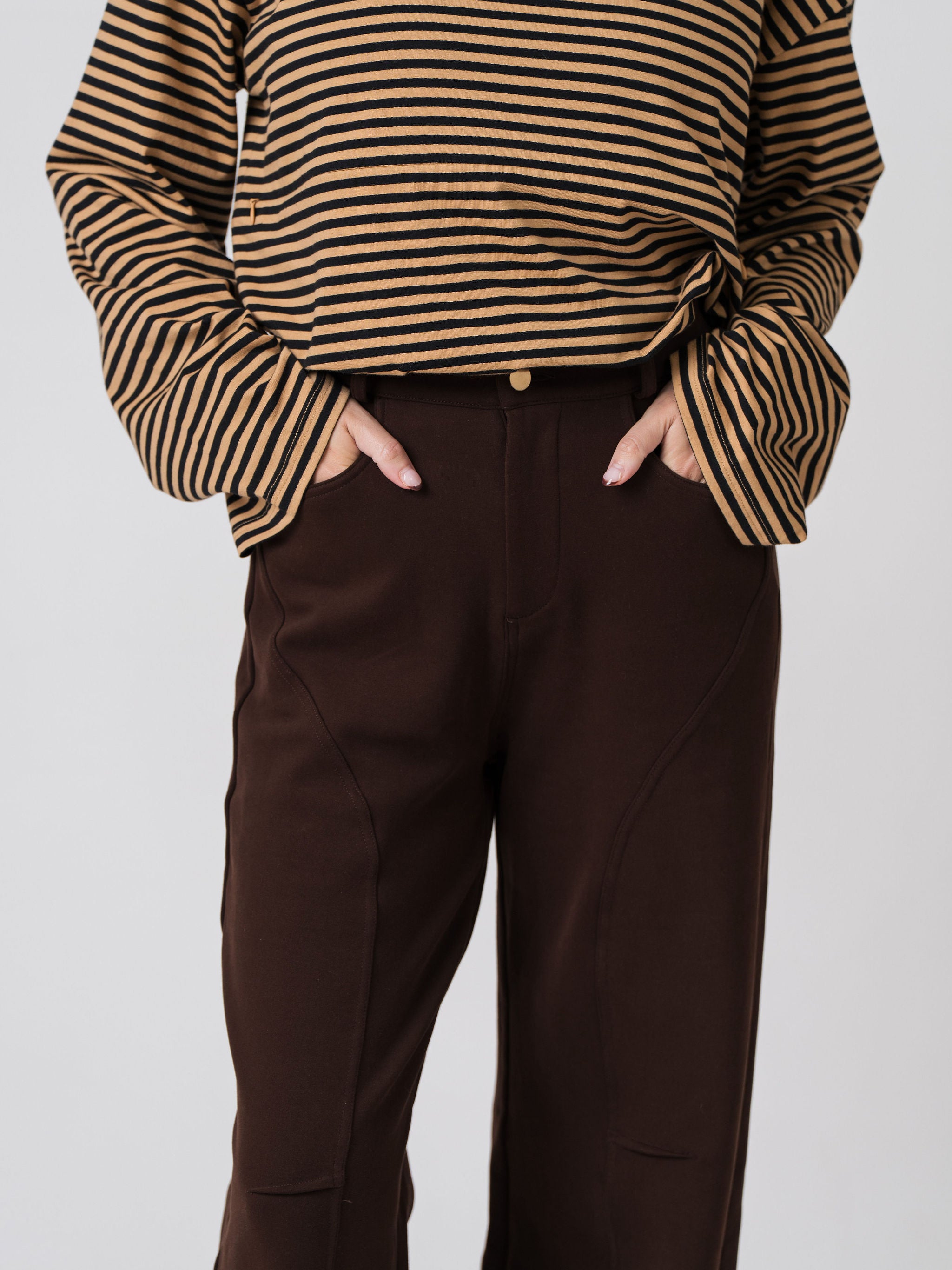 Close-up of the button and zip front and curved seam detailing on the Lenelly Mish sweatpants in chocolate