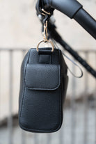 Lenelly Hera pram caddy bag in black vegan leather with adjustable strap, side view attached to a stroller