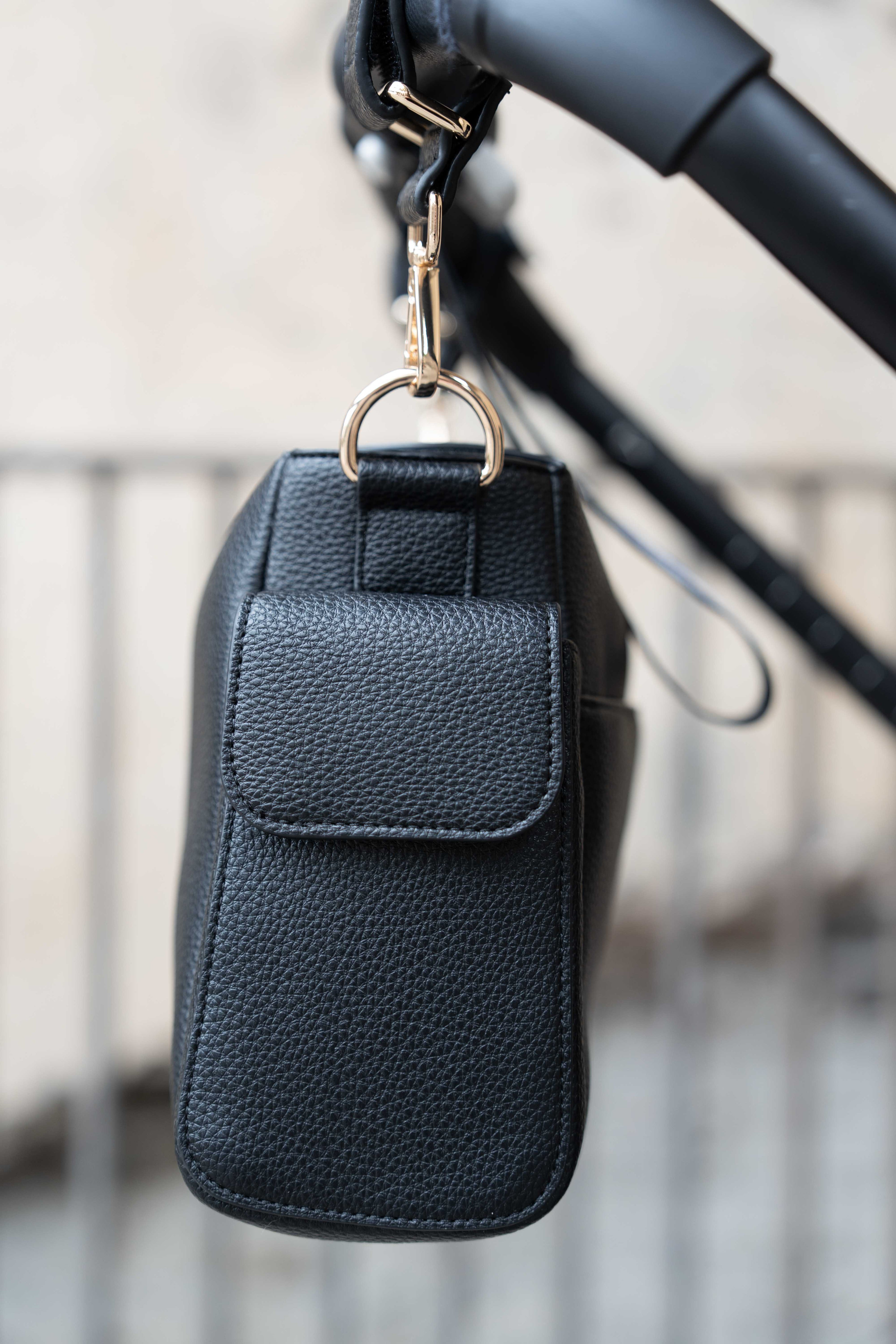 Lenelly Hera pram caddy bag in black vegan leather with adjustable strap, side view attached to a stroller