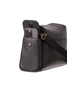 Lenelly Hera pram caddy bag in black vegan leather with adjustable strap, side view on white background with a phone in the side pocket