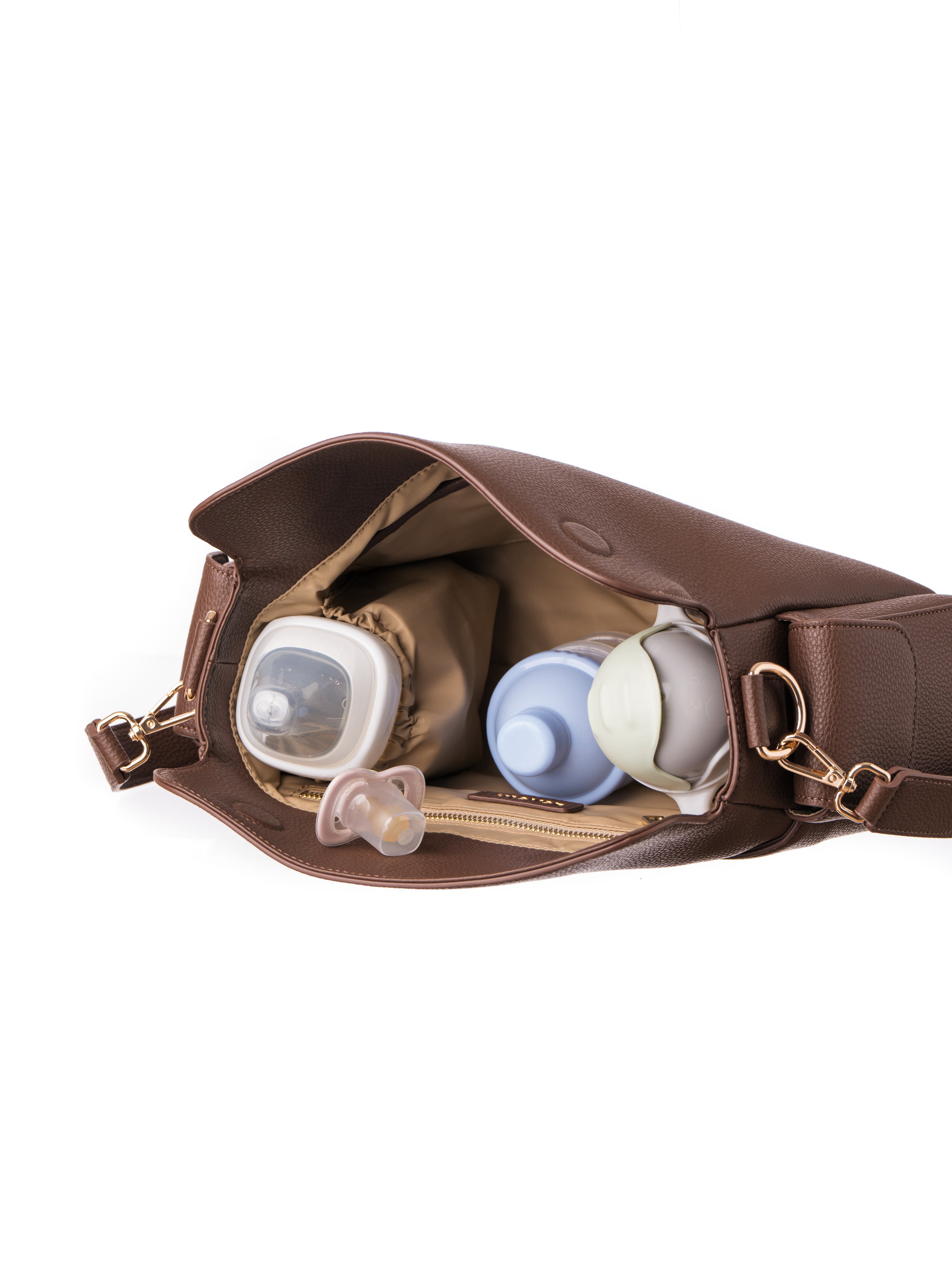 Lenelly Hera pram caddy bag in brown vegan leather with adjustable strap, styled interior view on white background with baby bottle, formula container, water sippy cup and dummy pacifier