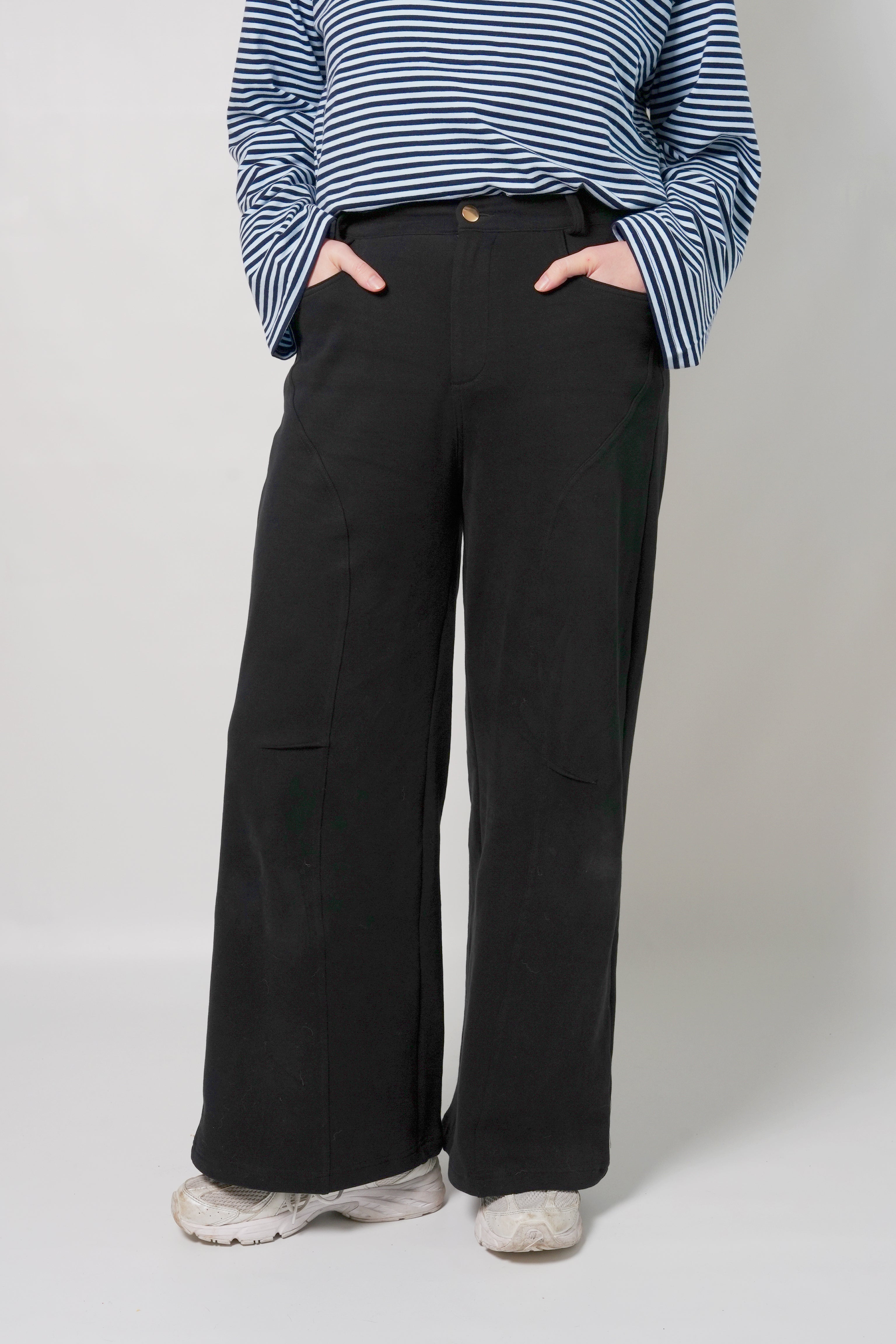 Lenelly Mish sweatpants in black styled with a navy striped long sleeve top, cropped front view with hands in the pockets